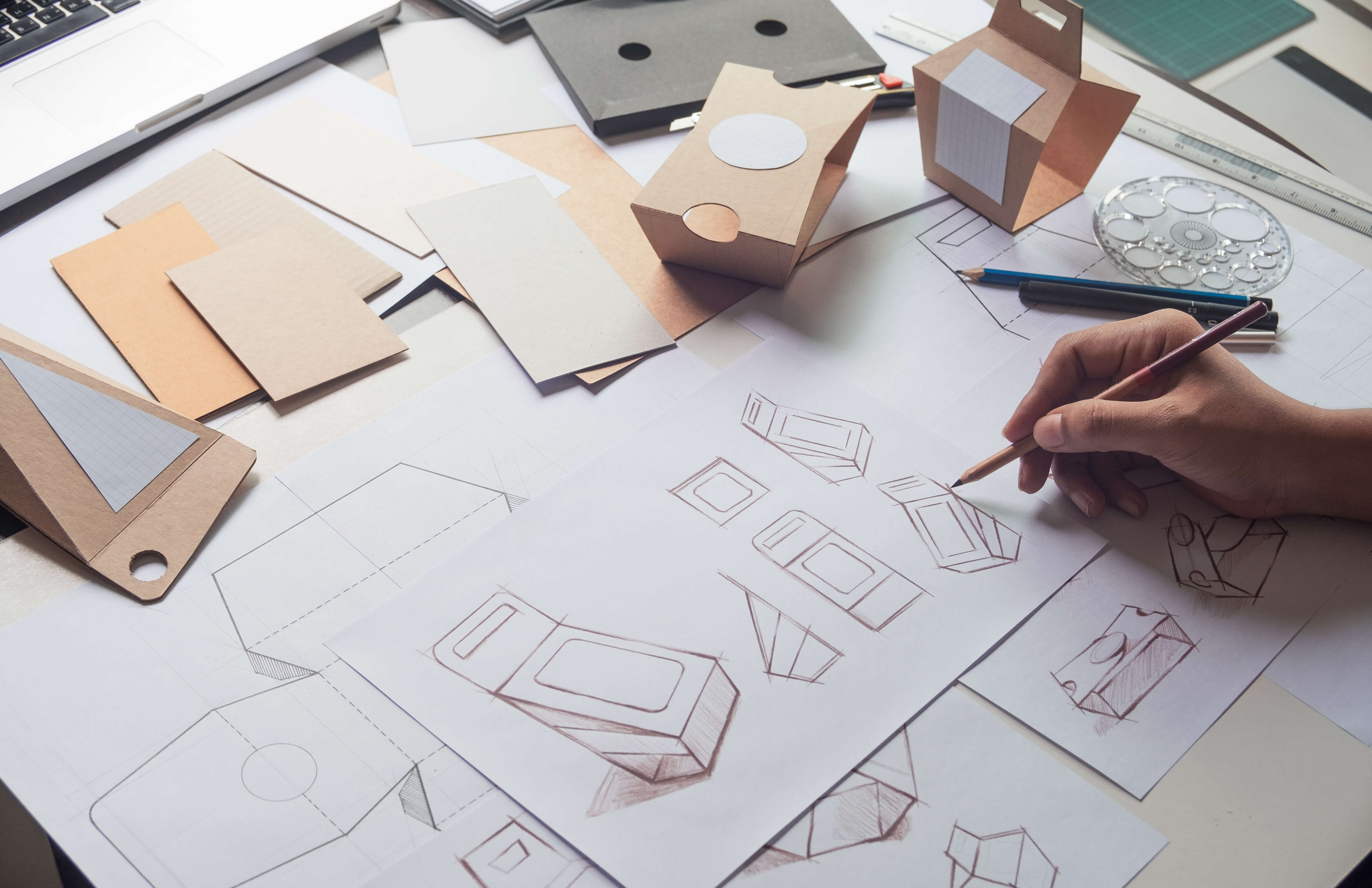 A designer drawing mock-up designs of a product.