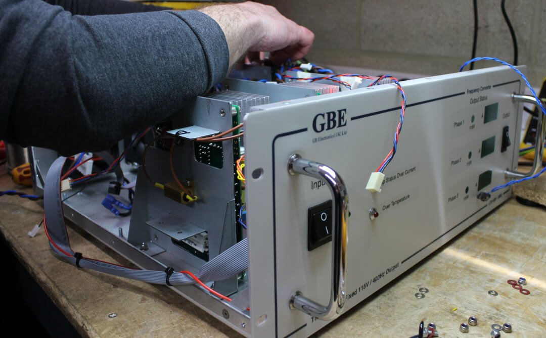 A close up of hands completing work on one of our frequency convertors