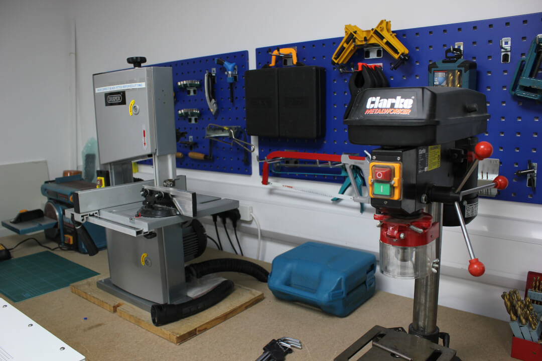 A view of a drill press and band saw in a workshop