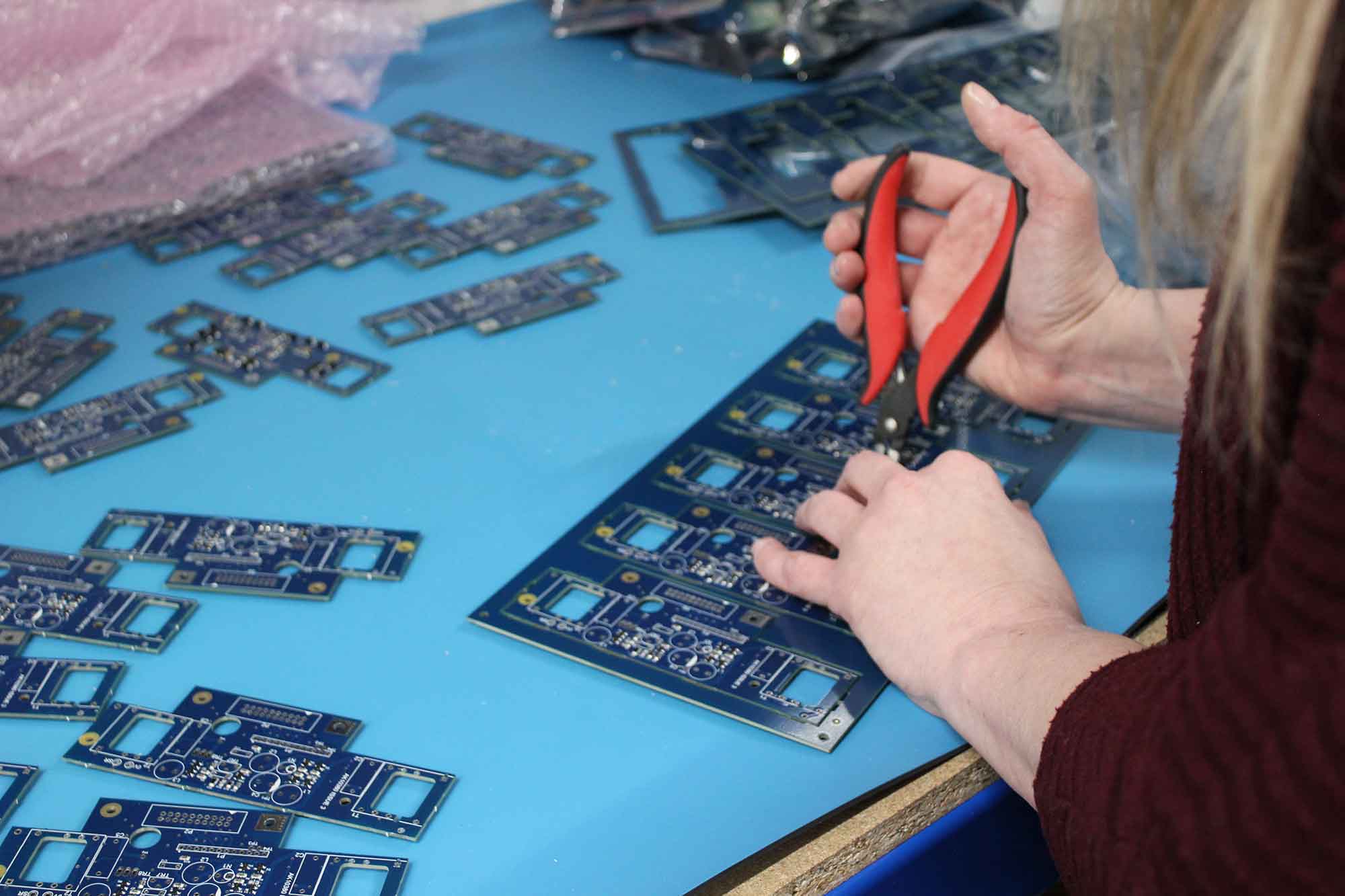 An image of an operator cutting out printed circuit boards on an ESD mat