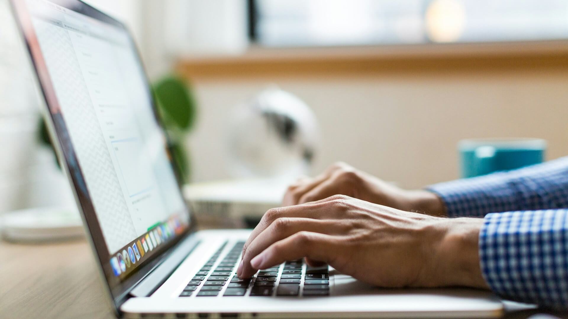 A man typing on a laptop to resemble contacting the GBE Team.