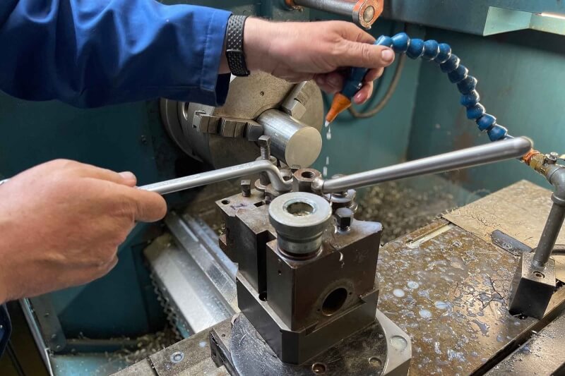 A man using mechanical equipment within a workshop