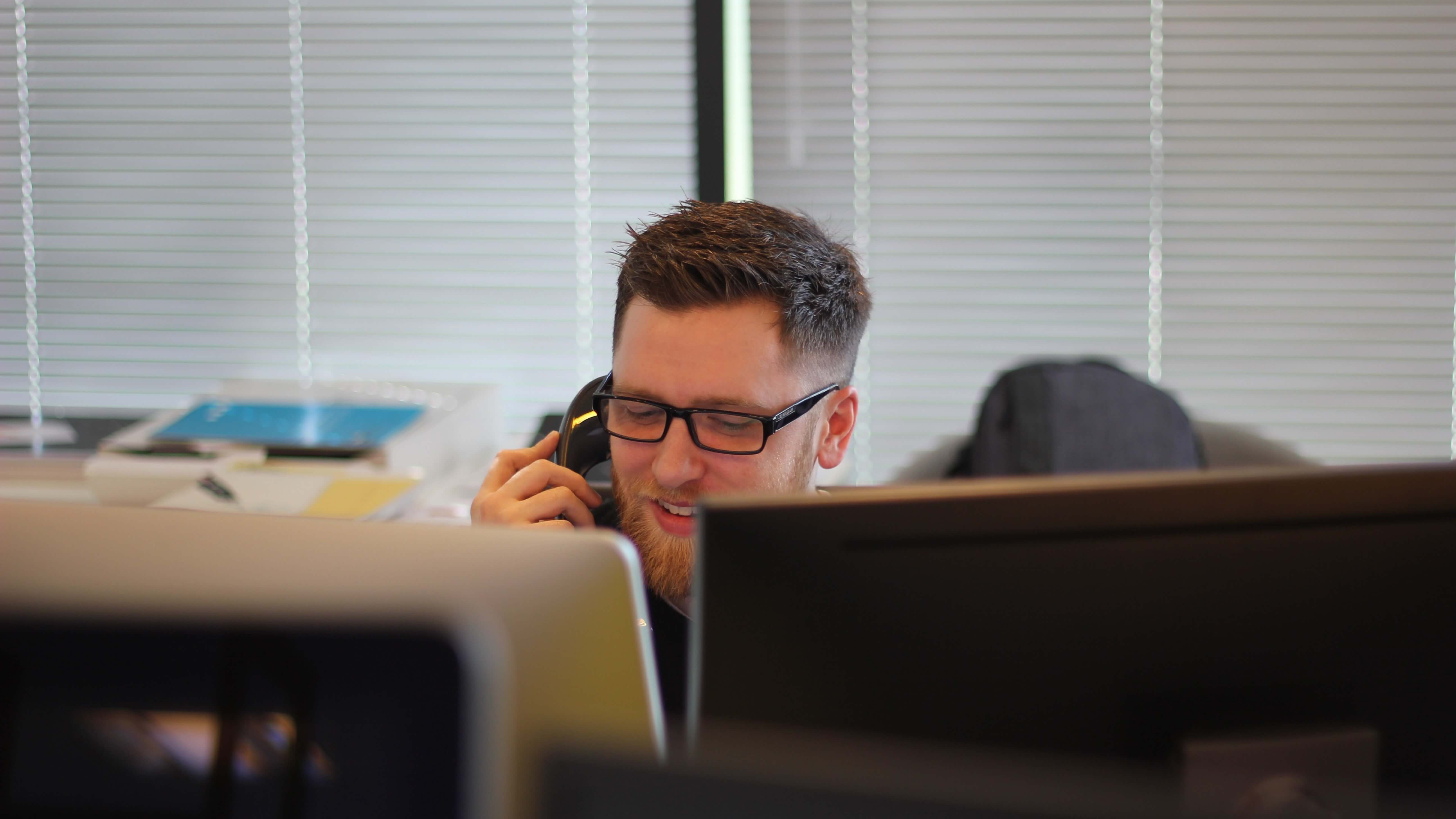 A man on the phone at his desk to resemble GB Electronics' ability to discuss solutions