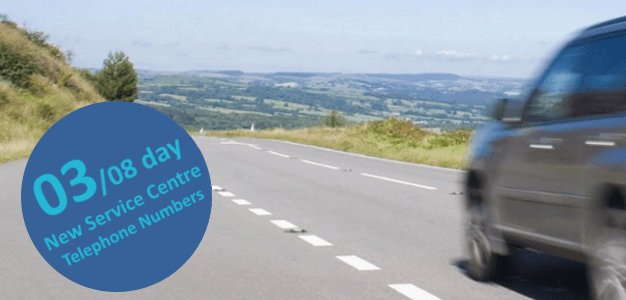 A car driving along an empty road with a circle banner that reads 03/08 day - new service centre telephone numbers.