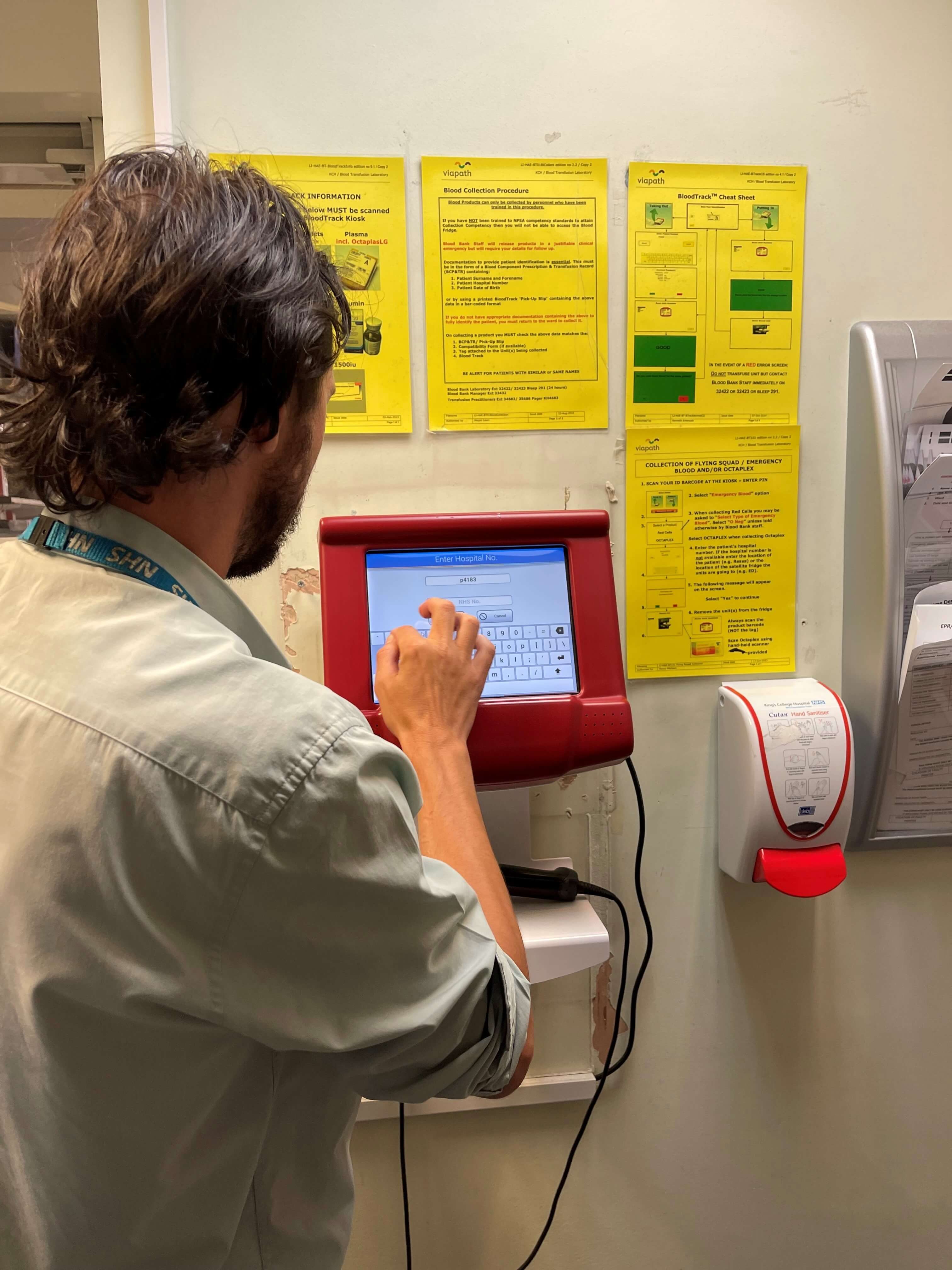 Blood Transfusion Practitioner at Kings College Hospital reviews a BloodTrack product that GBE helped to create./Blood Transfusion Practitioner at Kings College Hospital typing into a keypad that GBE helped to create./A cleaning robot at Kings College Hospital./A cleaning robot travelling the corridors at Kings College Hospital.